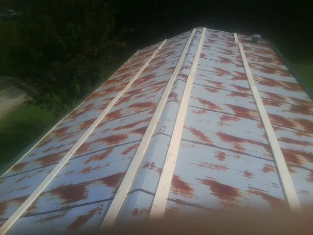 Rusted metal roof panels with new wood purlins before replacement — Storm Damage Roof Repair in Cedar Rapids by Roofing Brothers