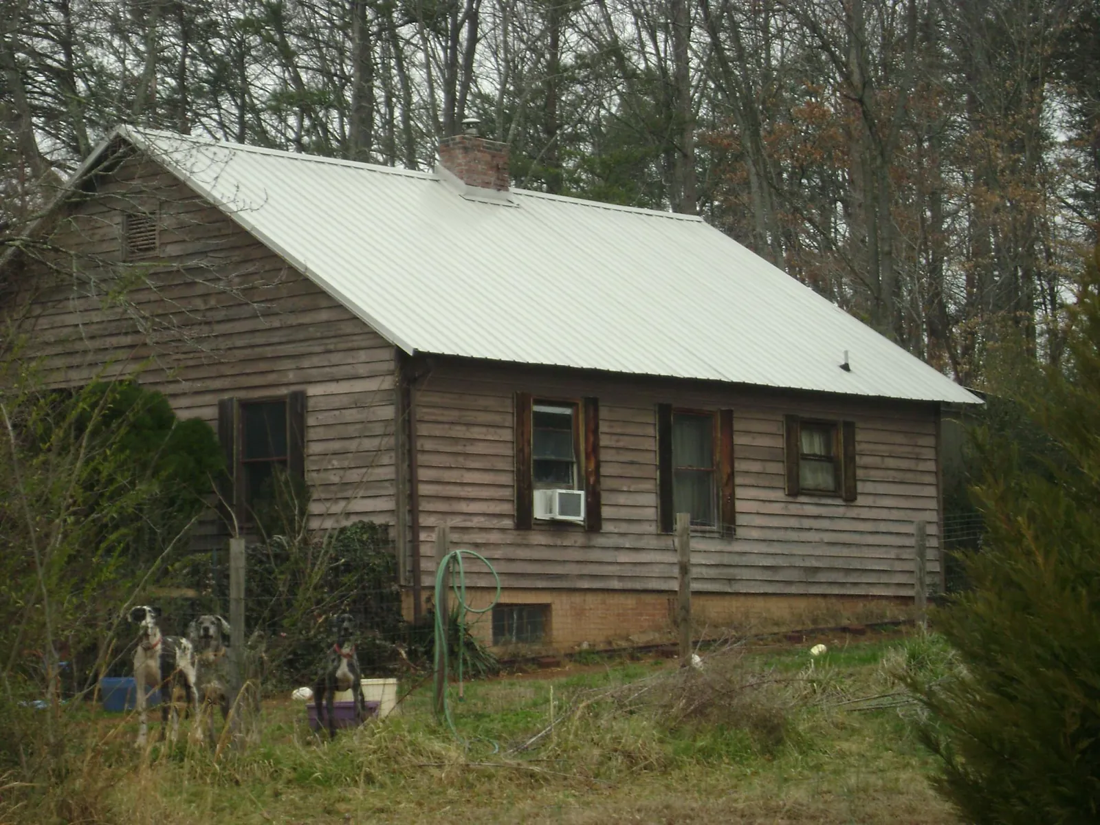 White metal roof on an old wood sided farmhouse, from a Metal Roof Installation job in Cedar Rapids